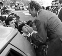 El Rey Juan Carlos se acerca a saludar a un grupo de niños que le esperaban en la calle a la salida del Tribunal Constitucional, donde inauguró la VI 